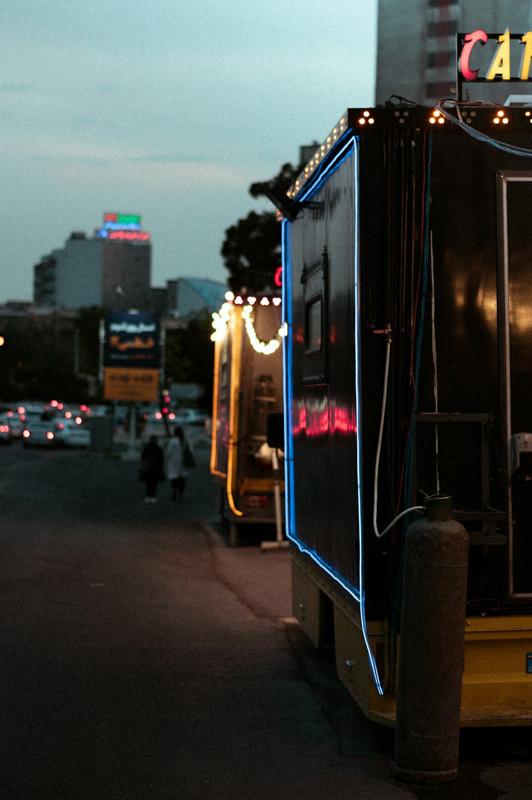 Outside broadcast truck with satellite dish parked on a city street at dusk