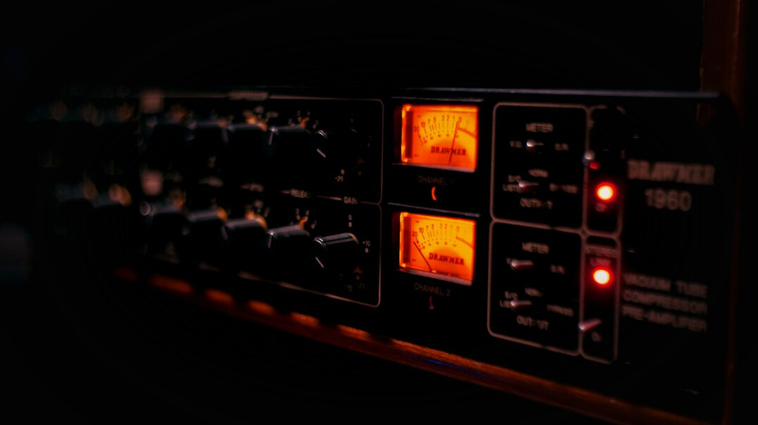 Racks of broadcast signal routing equipment with glowing status lights in a technical room